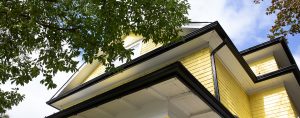 Architectural detail of the yellow shingles and black eaves of the Judith Holzman Law Office, serving the GTA.